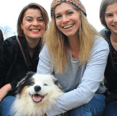 Smiling dog with three women